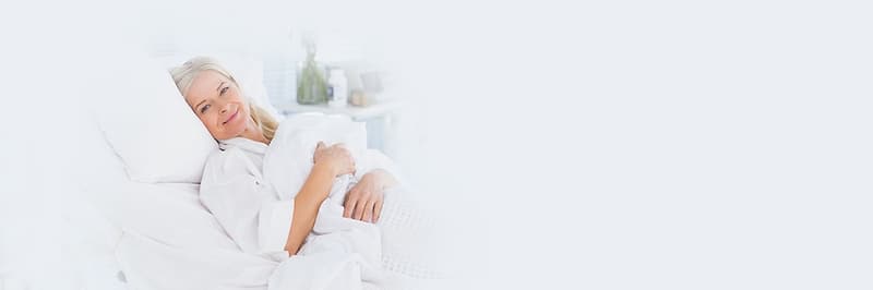 Glimlachende patiënte in een comfortabel bed